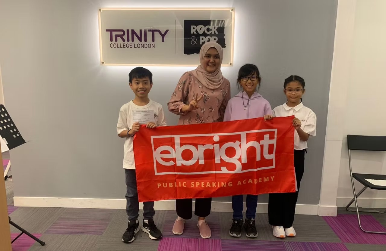 Students posing with Trinity College London collaboration banner